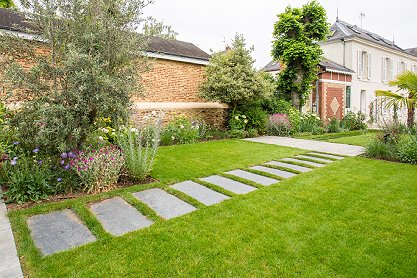 Une terrasse en bois avec un salon de jardin et une piscine dans le fond